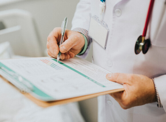 Médico segurando uma prancheta e uma caneta.